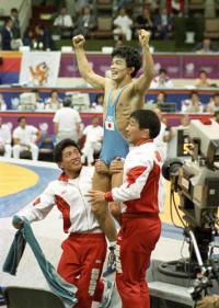 ８８年９月３０日、ソウル五輪レスリングのフリー５２キロ級で金メダルを獲得し、ガッツポーズする佐藤。左は高田コーチ