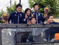 凱旋パレードを前に、歓迎する市民に囲まれ撮影に応じる千田健太（後列左）ら（共同）