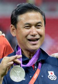 選手が獲得した銀メダルを手に笑顔の佐々木監督（共同）