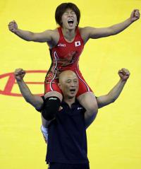 ０８年、北京五輪で金メダルを獲得した吉田を肩車しガッツポーズする栄監督