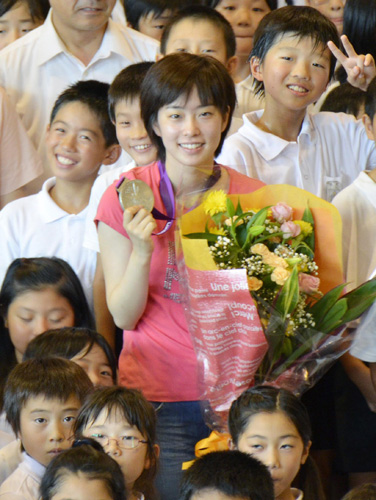 母校の平川小を訪れ、児童らに囲まれながら銀メダルを掲げる石川佳純（共同）